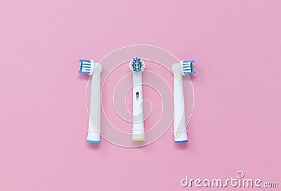Three toothbrush heads isolated on a pink background, with space for copy Stock Photo