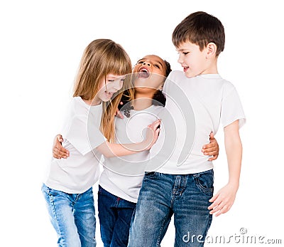 Three trendy children with different complexion laugh and embrace each other Stock Photo