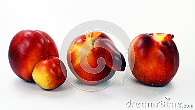 Three unusual shaped nectarine peaches isolated on white. Peach with a nose, double peach. Peaches freaks. Stock Photo
