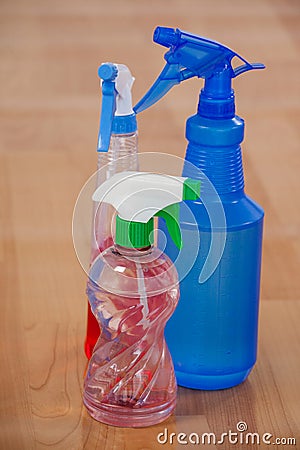 Three various spray bottles on wooden floor Stock Photo