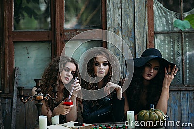 Three vintage witches perform magic ritual Stock Photo