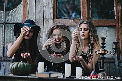 Three vintage witches perform magic ritual Stock Photo