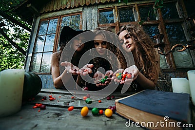 Three vintage witches perform magic ritual Stock Photo