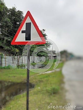 Three way junction warning sign board, intersection traffic sign on the roadside Stock Photo