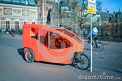 Three wheel orange vehicle in a city. Editorial Stock Photo