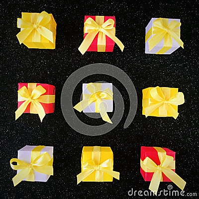 Nine colorful gift boxes are arranged in a nine-square grid on a black starry background. Stock Photo