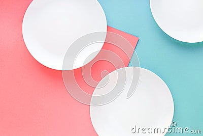 Three white plates on color background. Stock Photo