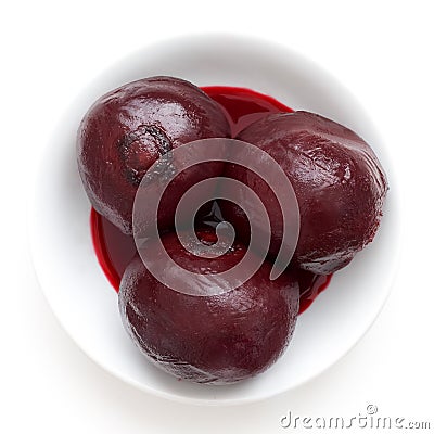 Three whole cooked beetroots in white dish isolated from above. Stock Photo