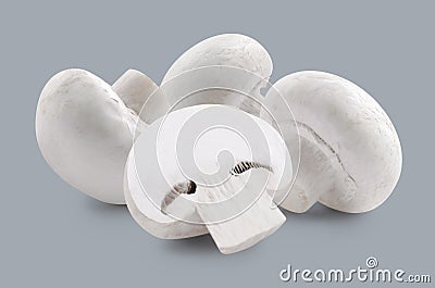 Three whole white mushrooms and slice on grey backgroun Stock Photo