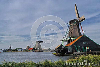 Heritage windmills along the shoreline typify Dutch landscape Stock Photo