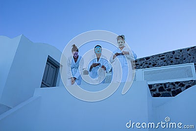 Three women in face masks and robes standing in a white building in Santorini, Greece. Editorial Stock Photo