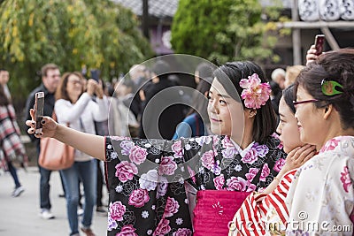 Three women in kimono taking selfie at Sensoji Buddhist temple T Editorial Stock Photo