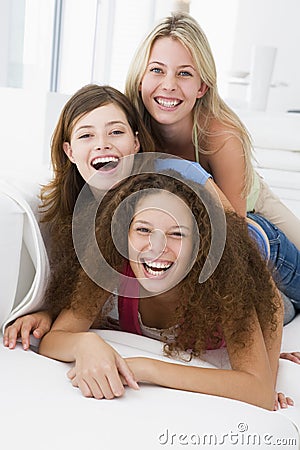 Three women in living room playing and smiling Stock Photo