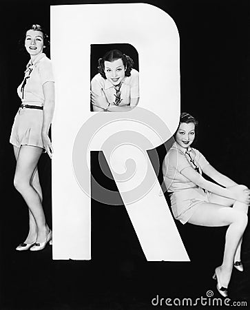 Three women posing with huge letter R Stock Photo