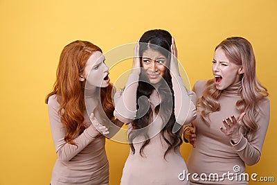 Three women screaming on their friend Stock Photo