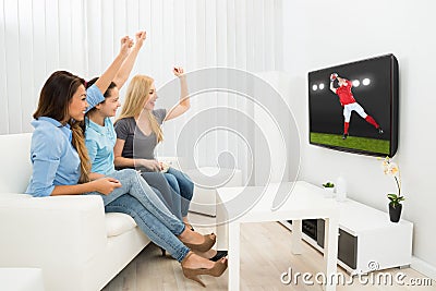 Three women watching rugby match Stock Photo