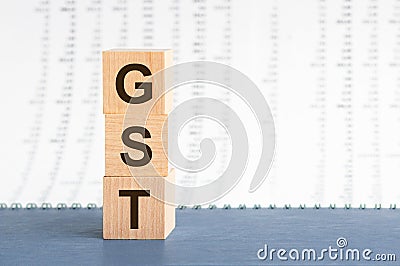 Three wooden cubes with letters GST - short for Goods and Services Tax, concept Stock Photo