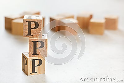 Three wooden cubes with letters PPP means Praise, Picture, Push, on white table, more in background, space for text in right Stock Photo