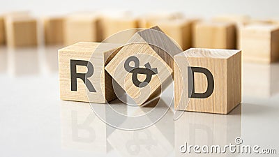 three wooden cubes with the letters R and D on the bright surface of a gray table, business concept Stock Photo