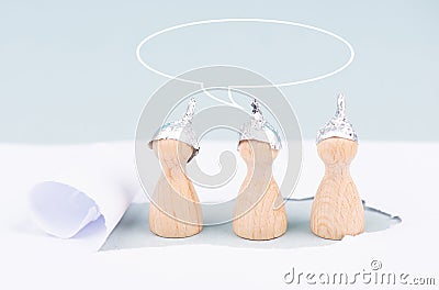 Three wooden figures wearing an alu hat,speech bubble conspiracy theories, tin foil Stock Photo