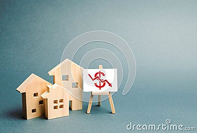 Three wooden houses with a stand with red dollar sign and arrow down. concept of real estate value decrease. low liquidity Stock Photo