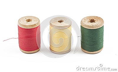 Three wooden multicolored thread coils on white Stock Photo