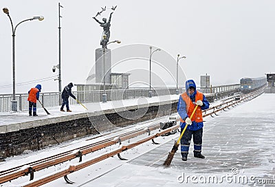 Three workers clear the subway station from snow during a heavy snowfall Editorial Stock Photo