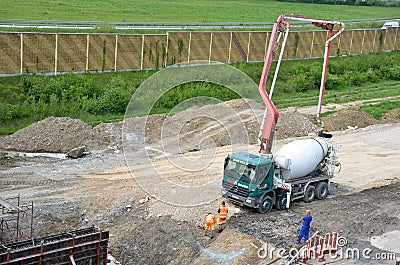 Three workers and concrete transport truck with concrete pump ready for use. This activity is related to railway reconstruction pr Editorial Stock Photo