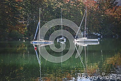 Three yachts on Lake Bohinj in autumn forestin in Slovenia Stock Photo