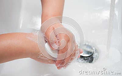 Child washing hands with soap Stock Photo