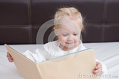 Three year old girl reading a book Stock Photo