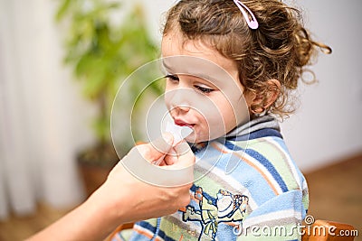 A three-year-old girl spits into a saliva test tube for covid19 antigens Stock Photo