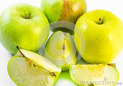 Three yellow and green apples and three slices on a white background Stock Photo