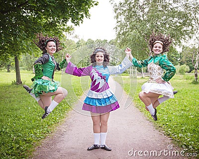 Three young beautiful girls in irish dance dress posing outdoor Stock Photo