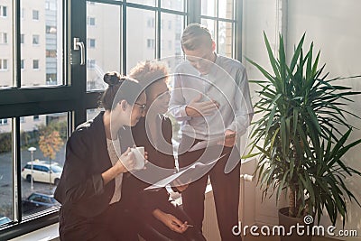 Three young cheerful employees smiling in a modern office Stock Photo