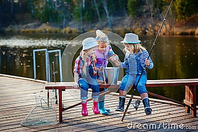 Three young children brag about fish caught on the bait. Concept of friendship and fun weekend or vacation Stock Photo