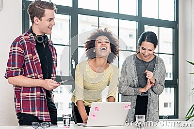 Three young colleagues laughing in the meeting room Stock Photo