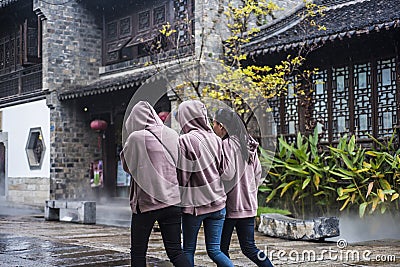 Three young girls in beige blouses walk through the scenic spot Editorial Stock Photo