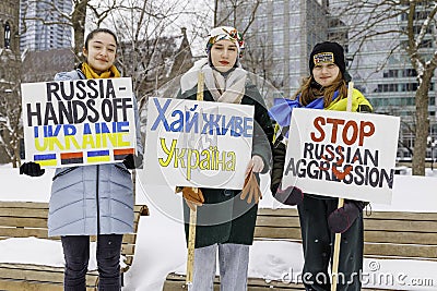 Montreal, Canada â€“ February 27 2022: Three young girls hold protest signs to protest Russian aggression in the Ukraine Editorial Stock Photo