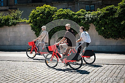 Three young men riding ebikes or. electric bikes of bicycle sharing service JUMP by UBER Editorial Stock Photo