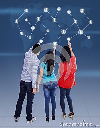 Three young people pressing a touchscreen Stock Photo