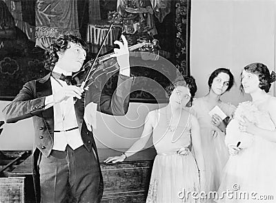 Three young women looking with adoration at a violin player Stock Photo