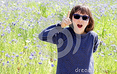 Thrilled expressive child with sunglasses over sunny cornflower meadow, outdoor Stock Photo