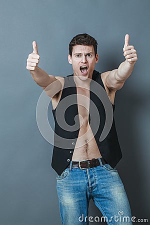 Thrilled 20s sportsman with bare chest and thumbs up shouting Stock Photo