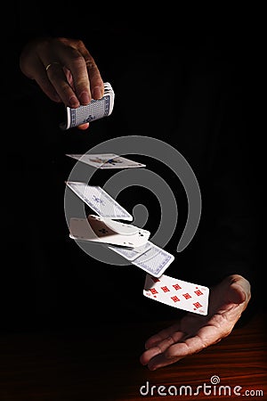 throwing cards from one hand to the other against a black background with copy space, business metaphor or concept for new Stock Photo