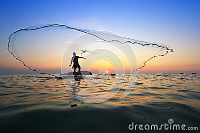 Throwing fishing net during sunrise Stock Photo
