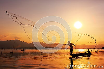 Throwing fishing net during sunset Stock Photo