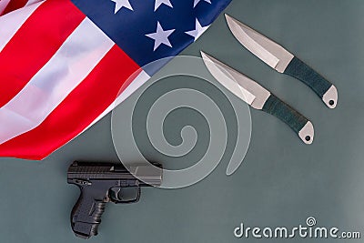 Throwing knives, pistol, american flag flat lay on gray background. United States Gun Laws - Guns and weapons Stock Photo