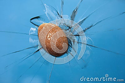 The thrown stone hits and shatters the window glass Stock Photo