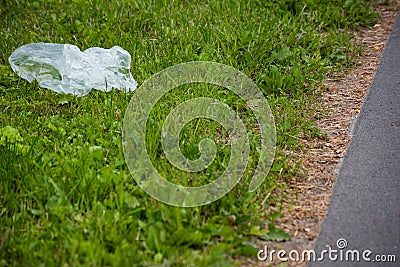 Thrown white bag on the curb with green grass Stock Photo